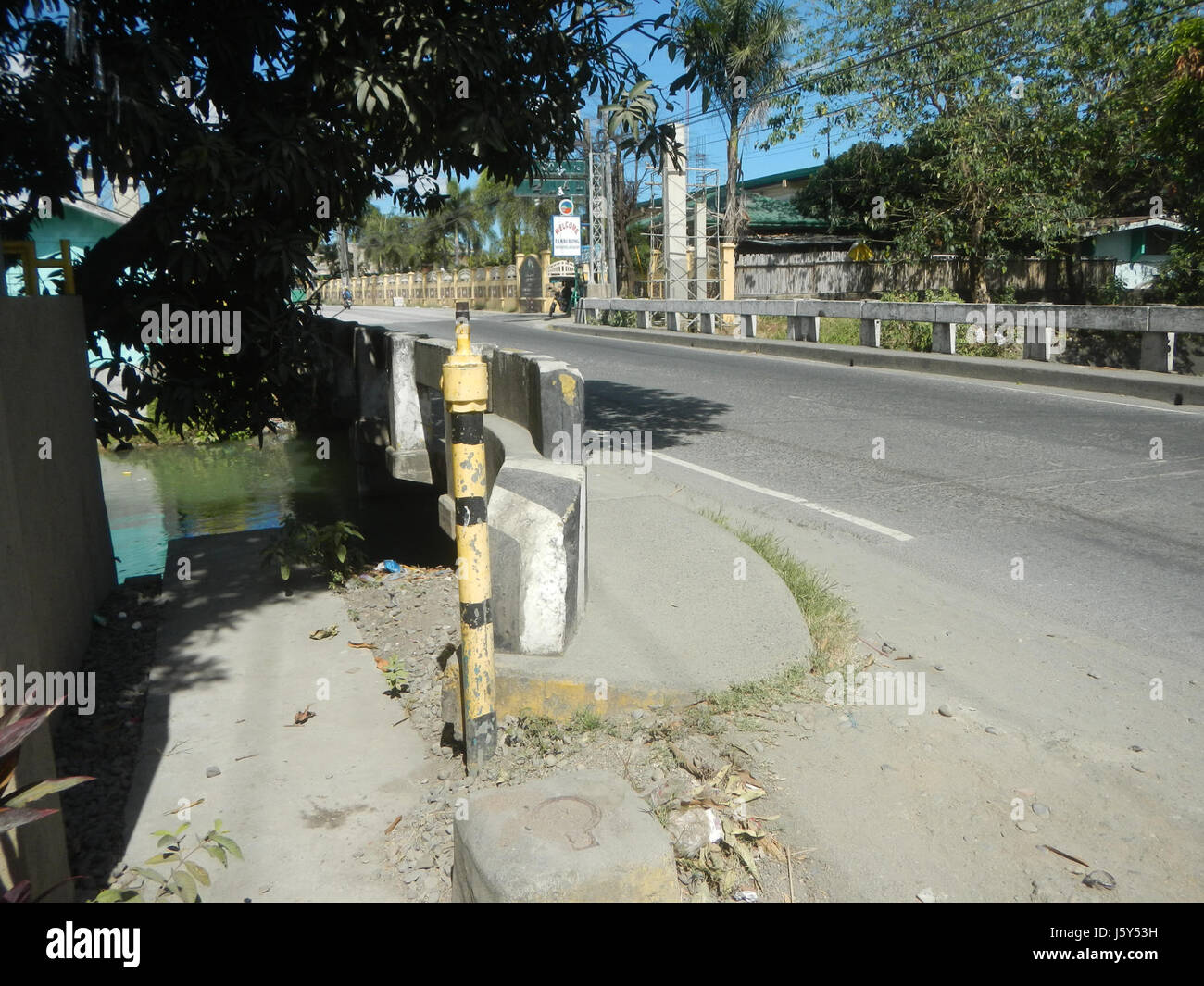 Le pont frontalier Sabang-Baliuag, situé à Bulacan, sert de pièce d'infrastructure importante, facilitant la circulation entre les zones voisines comme Tambubong et San Rafael, tout en soutenant les systèmes d'irrigation pour l'agriculture locale. Banque D'Images