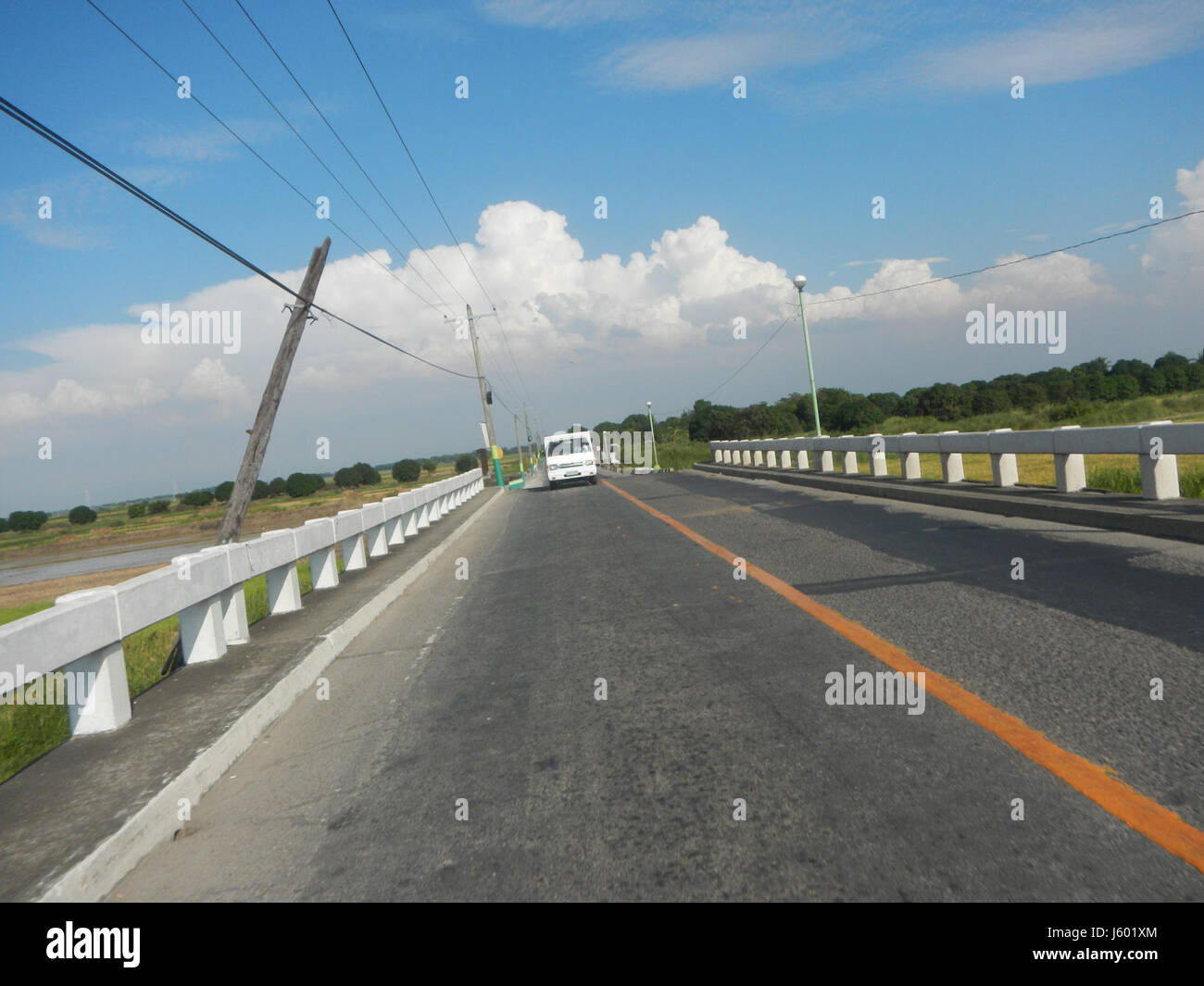 Cette image illustre la réhabilitation des routes dans les zones de Santa Monica et San Isidro à San Luis, Pampanga, en se concentrant sur les améliorations des infrastructures dans la région pour soutenir les transports et le développement local. Banque D'Images