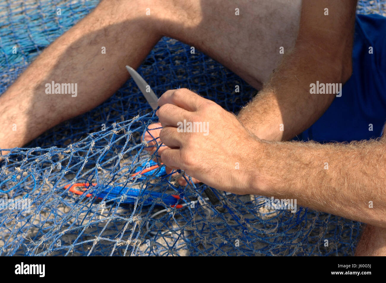 Main mains réparation filet de pêche pêche résille bleu aliment alimentaire poissons main mains Banque D'Images