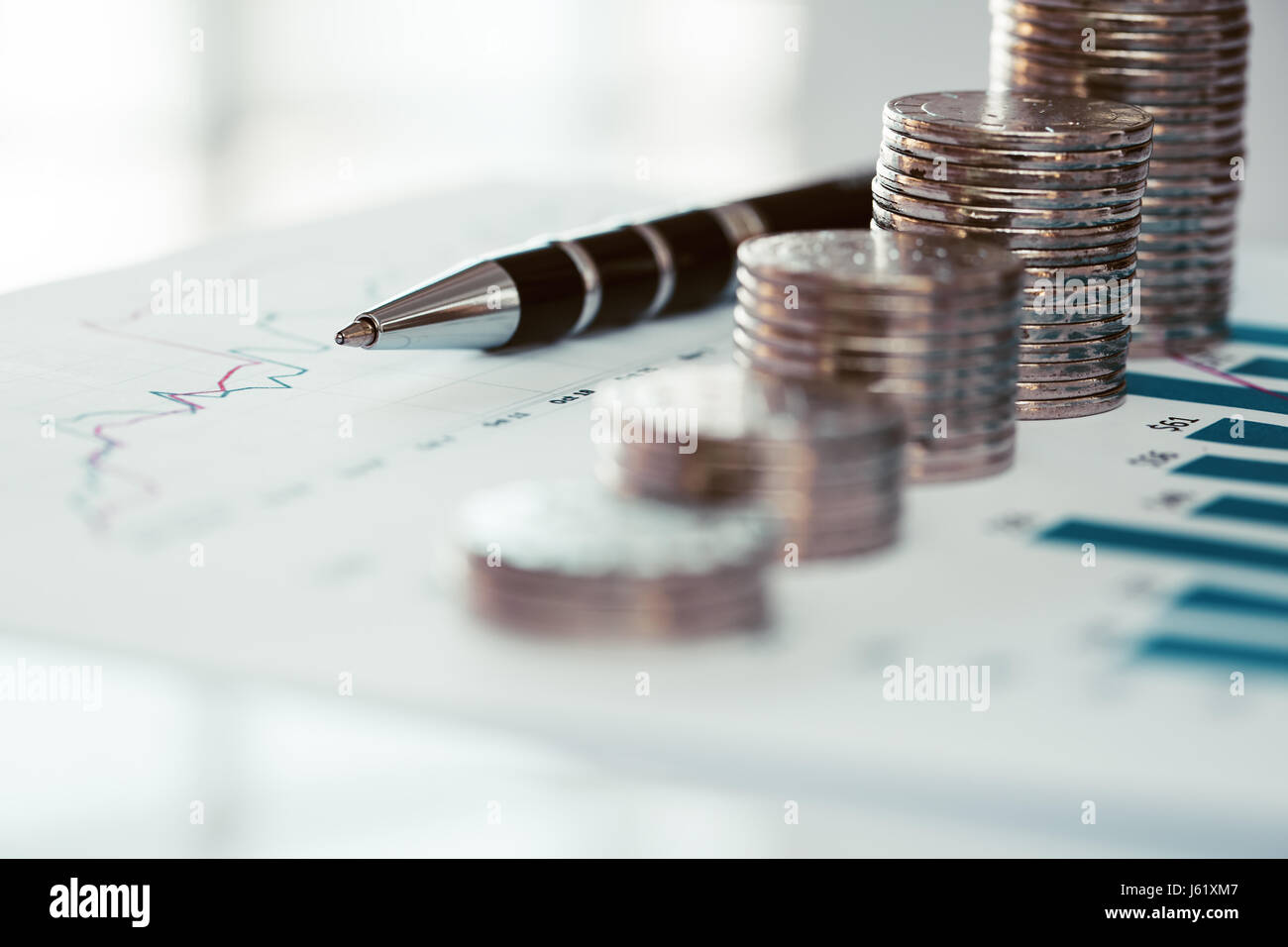 Pile de pièces avec des graphique en courbes et pen Banque D'Images
