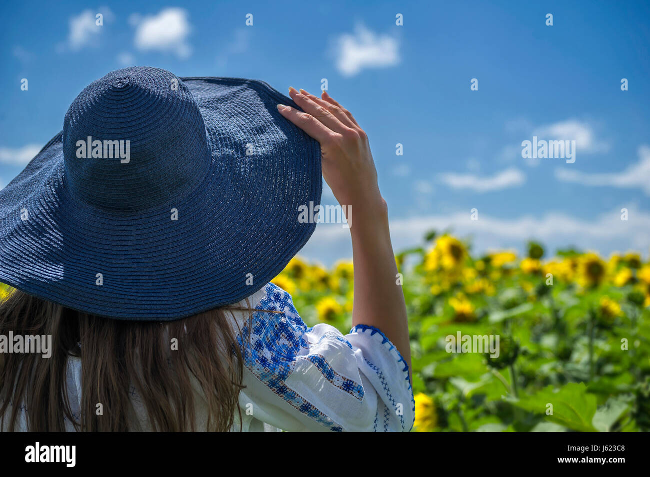 Femme portant une blouse traditionnelle moldave cousues main à plus d'un champ de tournesol, près de Vanatori village de Moldova, Roumanie Banque D'Images