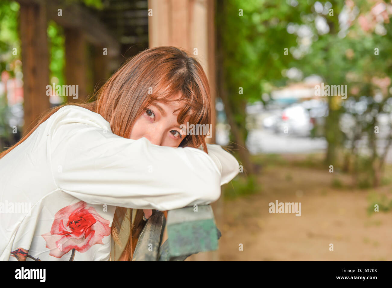 Young Asian woman sitting in chair outdoor et looking at camera Banque D'Images