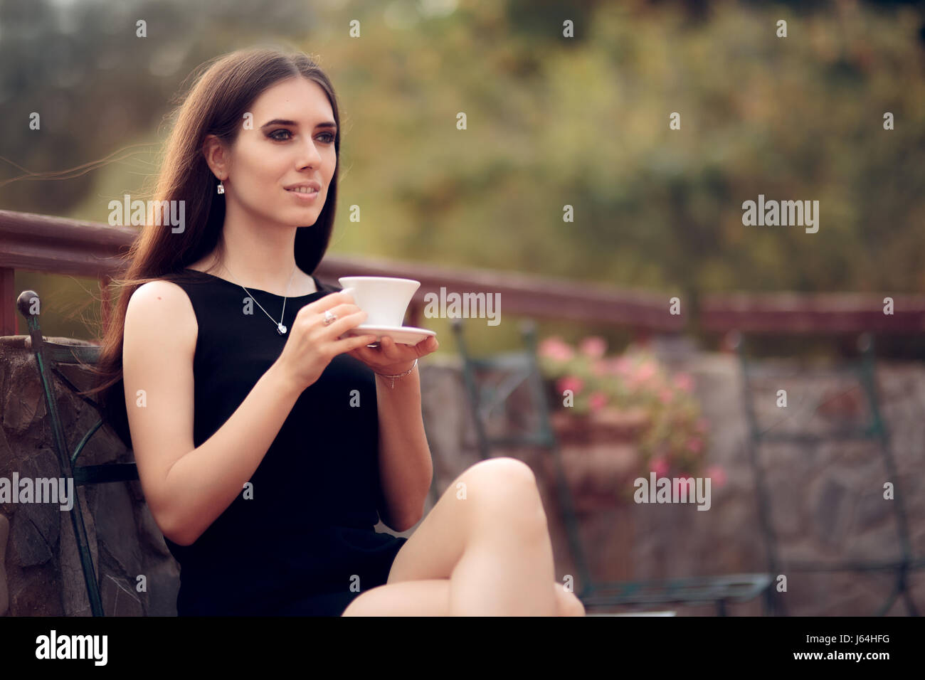 Femme élégante de boire un café dans le jardin Banque D'Images