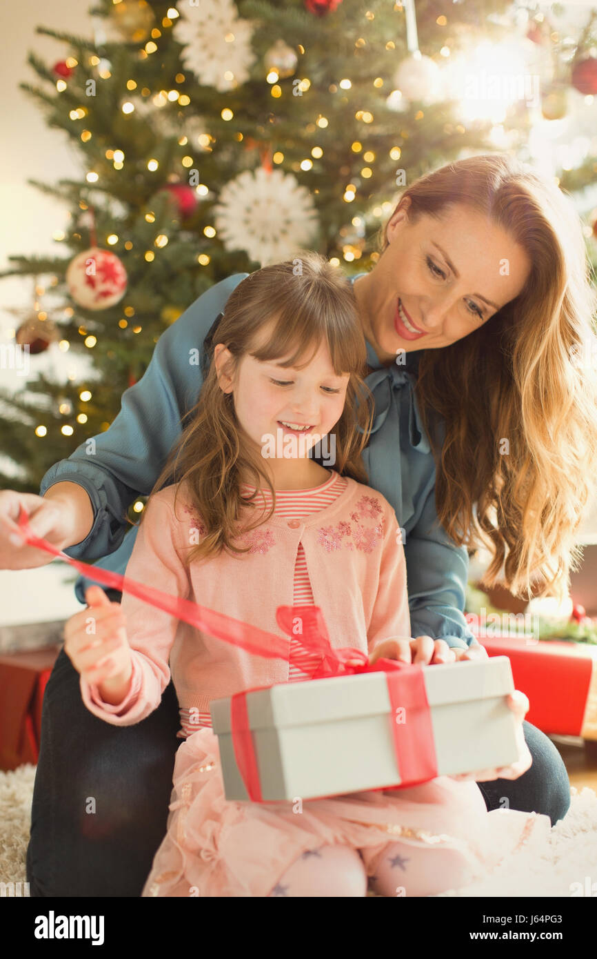 Mother helping daughter ouvrir cadeau de Noël Banque D'Images