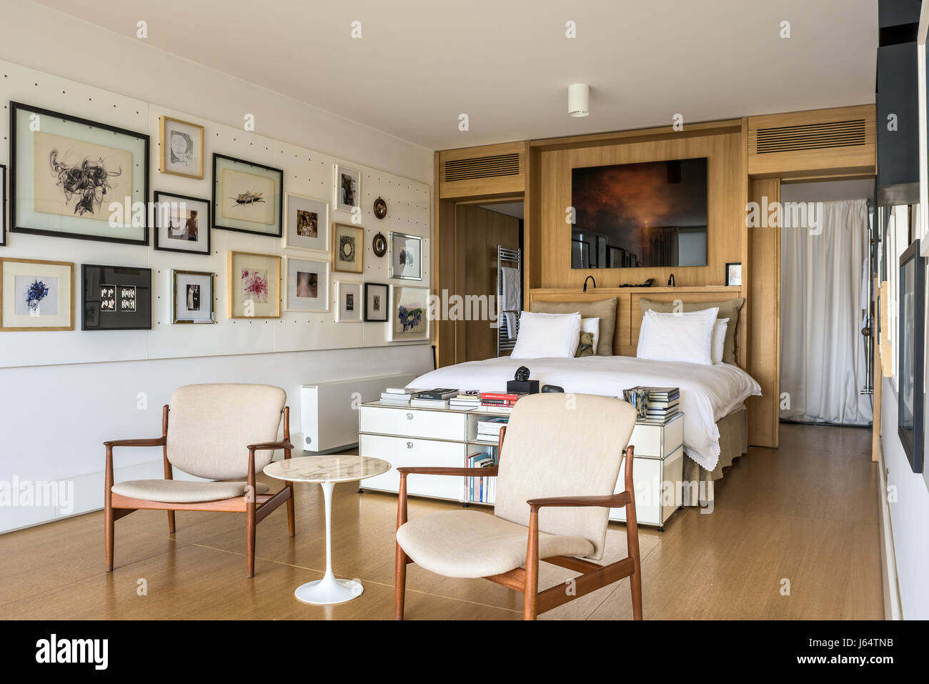 Paire de chaises au milieu du siècle dans des master chambre décorée avec un assortiment d'art et de la photographie. L'imprimer au-dessus du lit est par Hiroyuki Masuya Banque D'Images