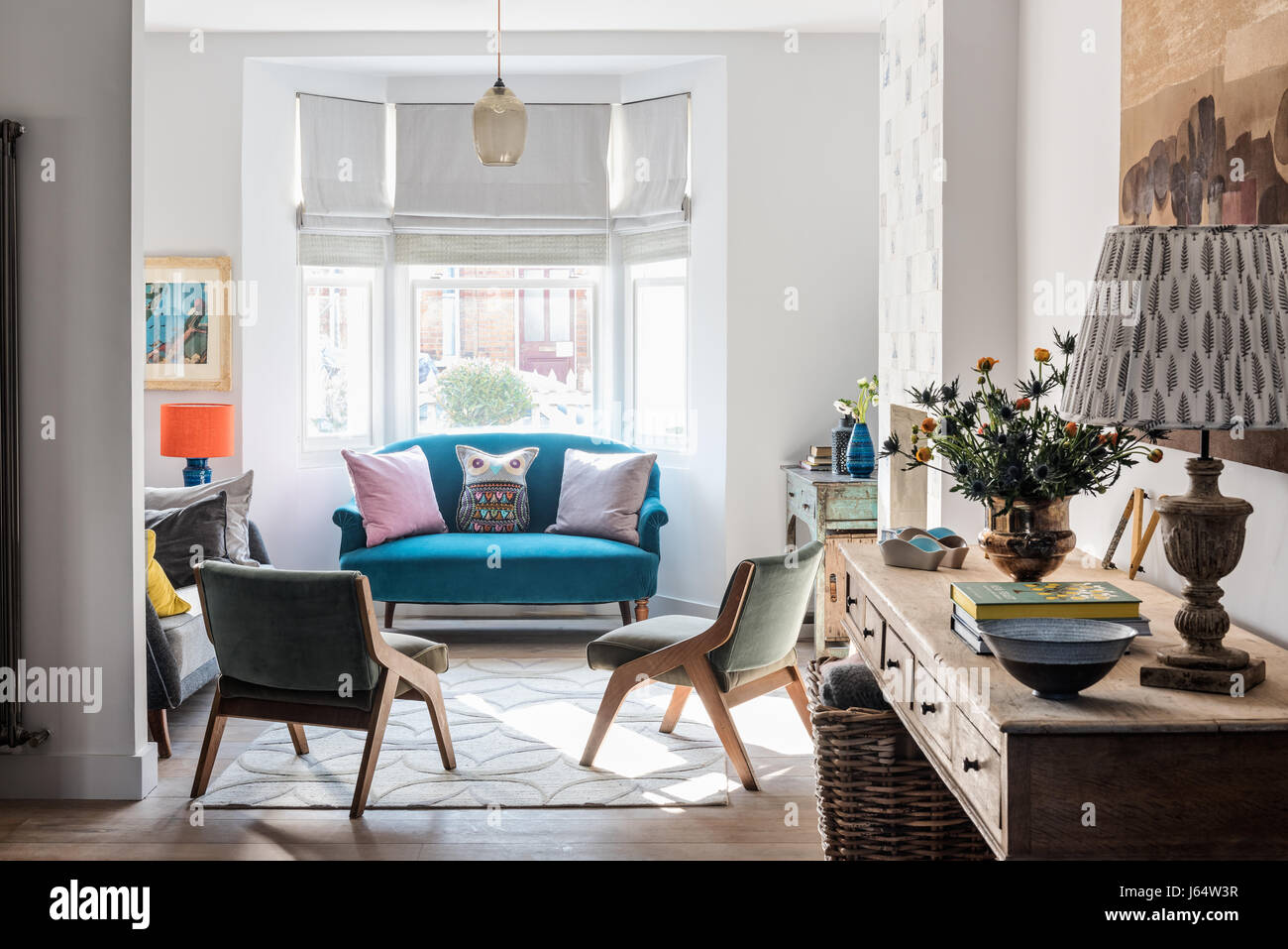 Lieu de vie ouvert avec une longue table console en bois rustique et vintage canapé rembourrés en Ashton dans Teal de Wemyss Banque D'Images