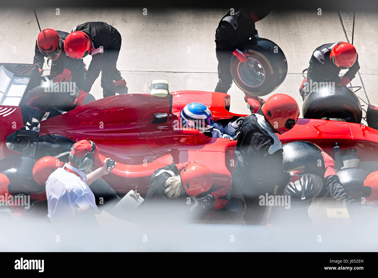 Manager avec chronomètre pit crew du remplacement des pneus de voiture de course de Formule 1 dans la voie des stands Banque D'Images