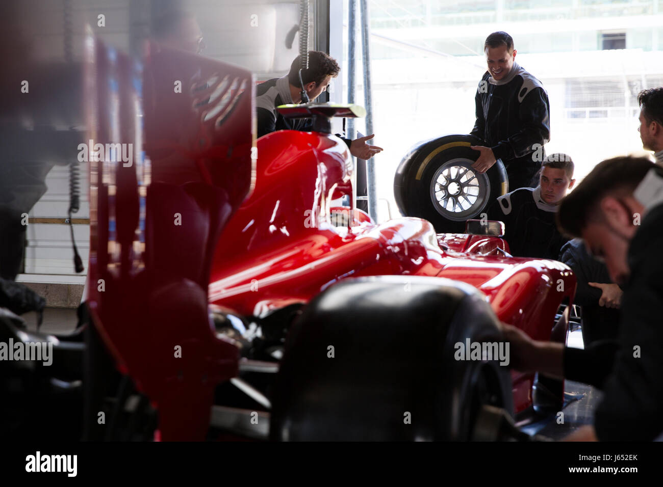 Pit Crew travaillant sur course de Formule 1 voiture dans un garage de réparation Banque D'Images
