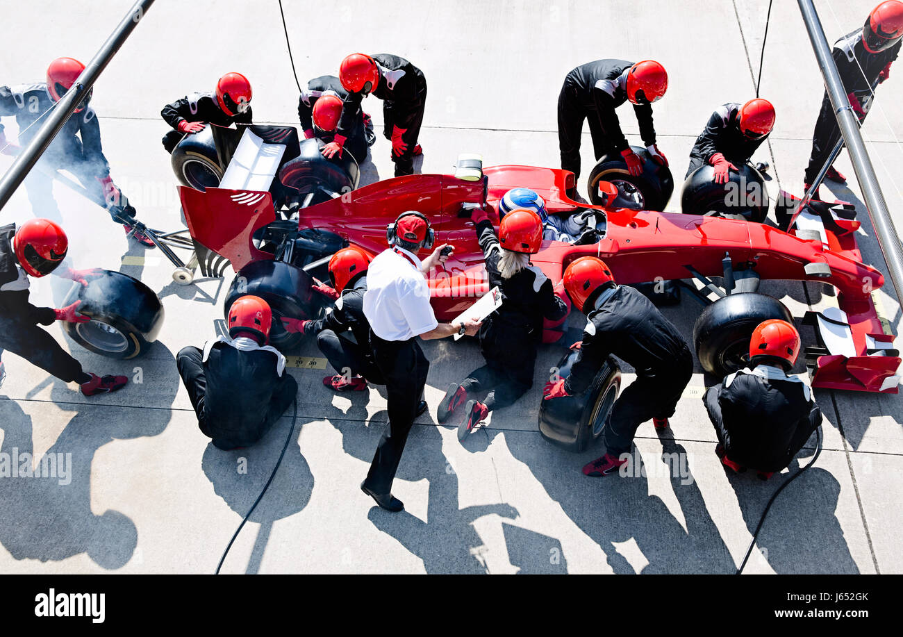 Manager avec chronomètre pit crew du remplacement des pneus de voiture de course de Formule 1 dans la voie des stands Banque D'Images