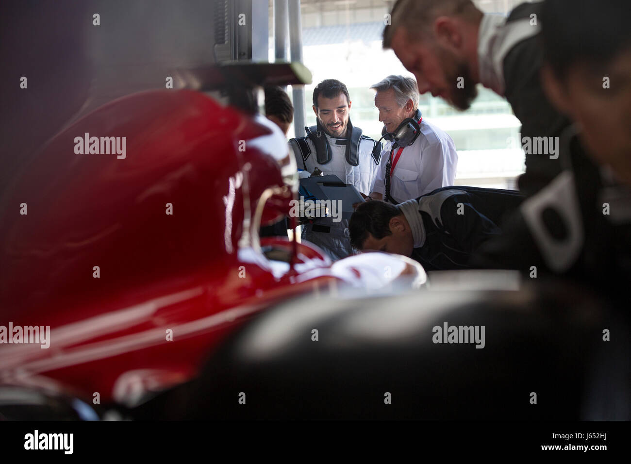 Manager et pilote de voiture de course de Formule Un à parler de réparation automobile Banque D'Images