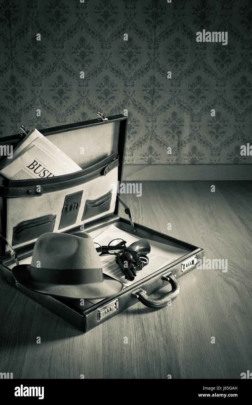 Porte-documents en cuir vintage ouvert avec chapeau de détective, revolver fusil et journal. Banque D'Images