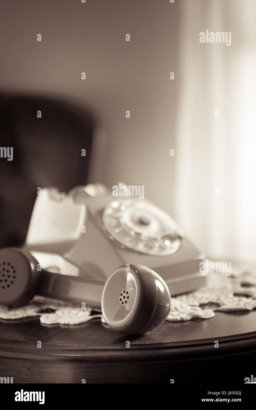 Vintage téléphone le napperon et table ronde en bois avec combiné en attente. Banque D'Images