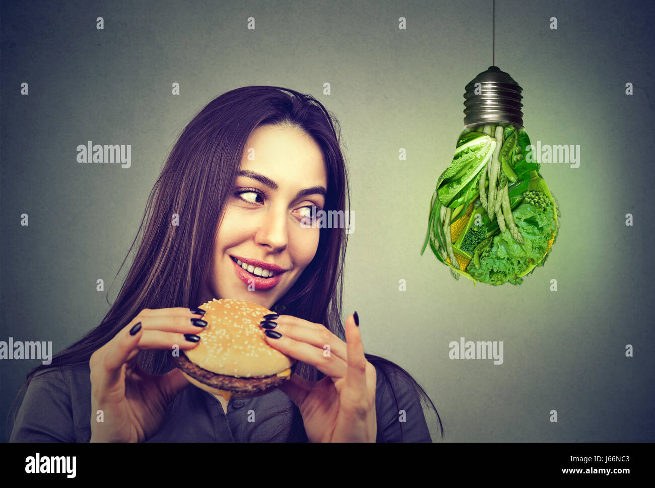 Femme avec hamburger pense à d'autres choix de régime Banque D'Images