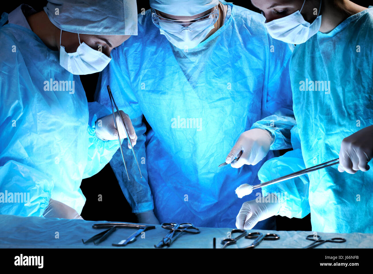 L'équipe médicale d'effectuer l'opération. Groupe de chirurgien à l'œuvre dans les tons d'opération en bleu Banque D'Images