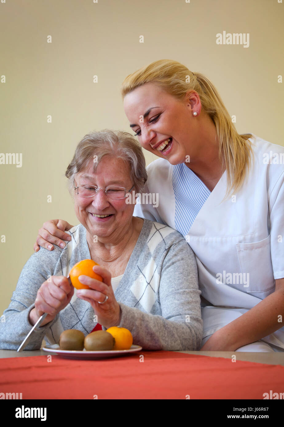 Clinique de jour de gériatrie. Une jeune femme en service volontaire social, bénévole de l'année sociale, FSJ prend en charge un patient dans la vie quotidienne. Tagesklinik eines Banque D'Images