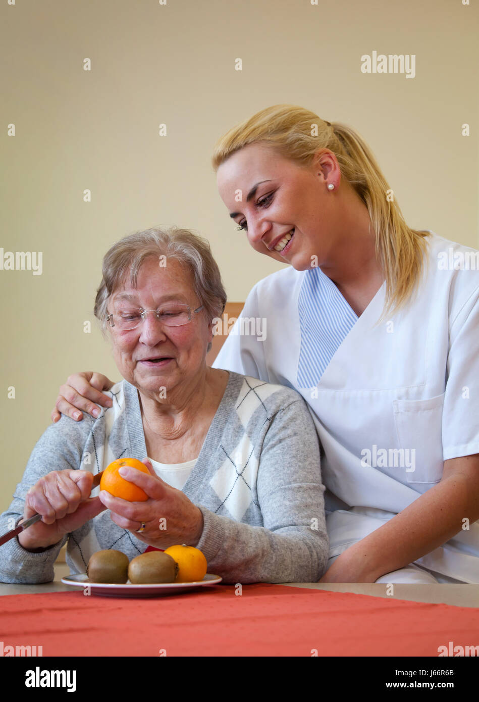 Clinique de jour de gériatrie. Une jeune femme en service volontaire social, bénévole de l'année sociale, FSJ prend en charge un patient dans la vie quotidienne. Tagesklinik eines Banque D'Images