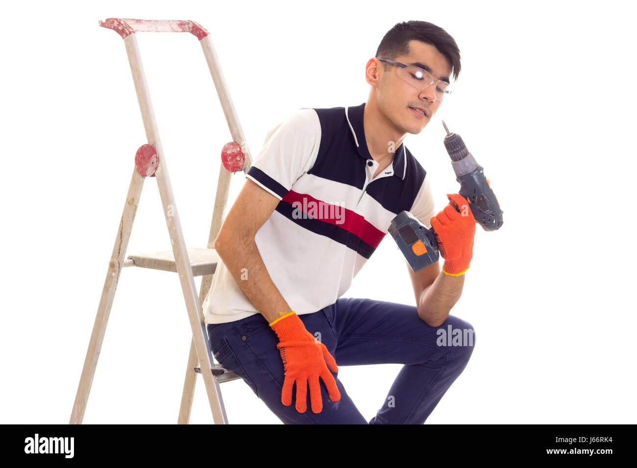 Young man holding tournevis électrique et assis sur ledder Banque D'Images