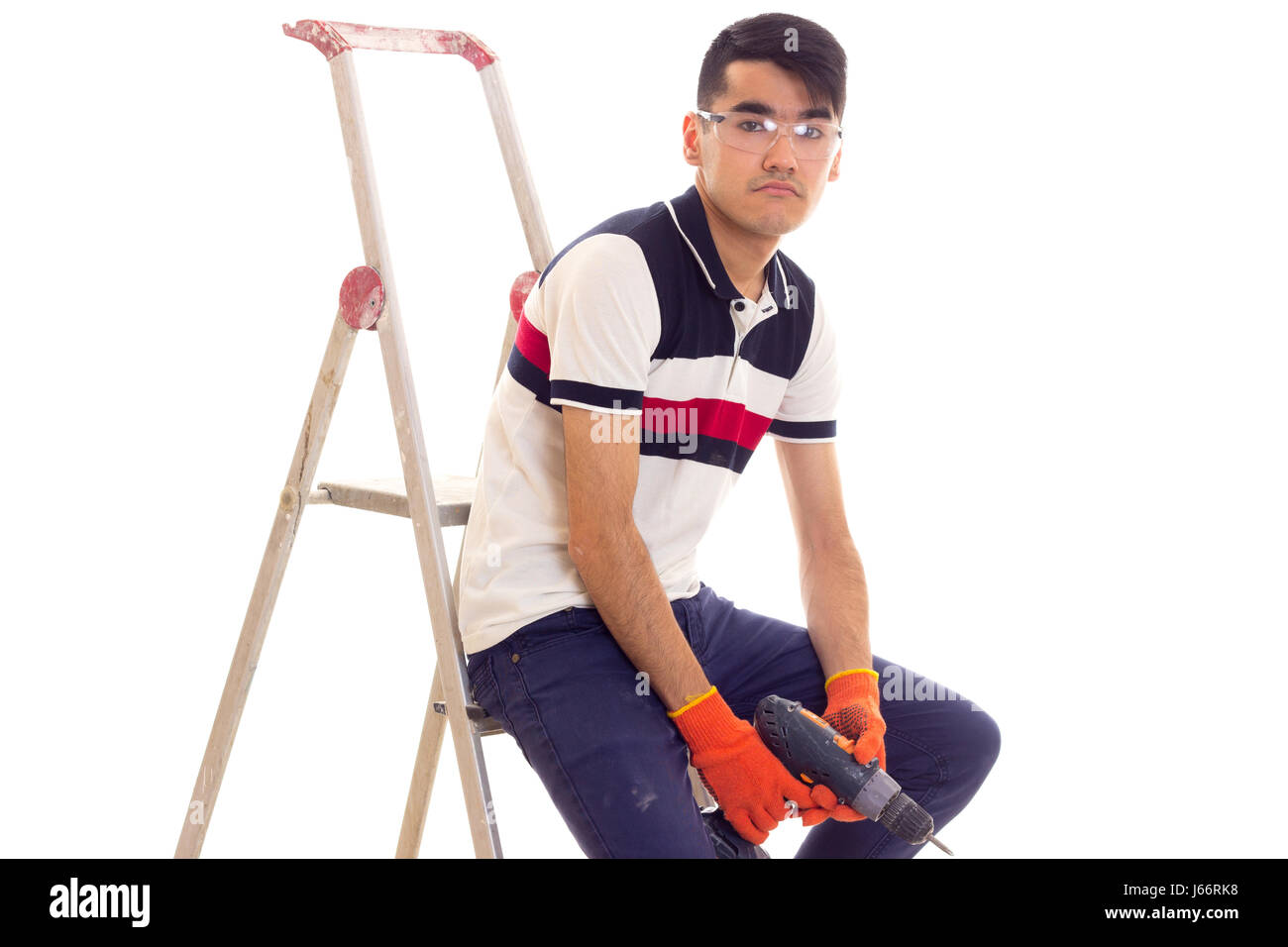 Young man holding tournevis électrique et assis sur ledder Banque D'Images
