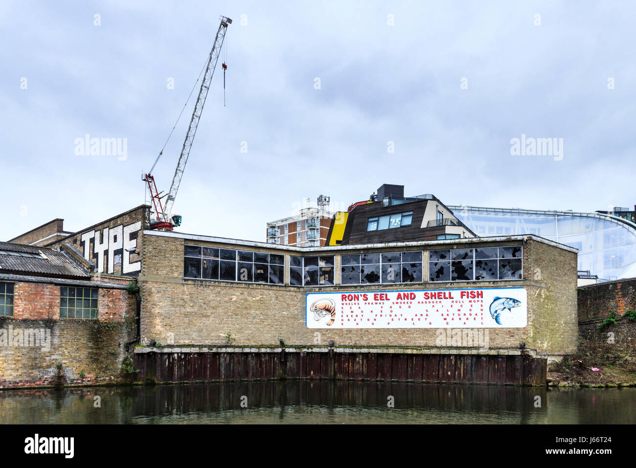 'Ron's anguilles et coquillages", une enseigne peinte se référant à un atelier local sur la façade d'un entrepôt à l'abandon sur Regent's Canal, Shoreditch, London, UK Banque D'Images