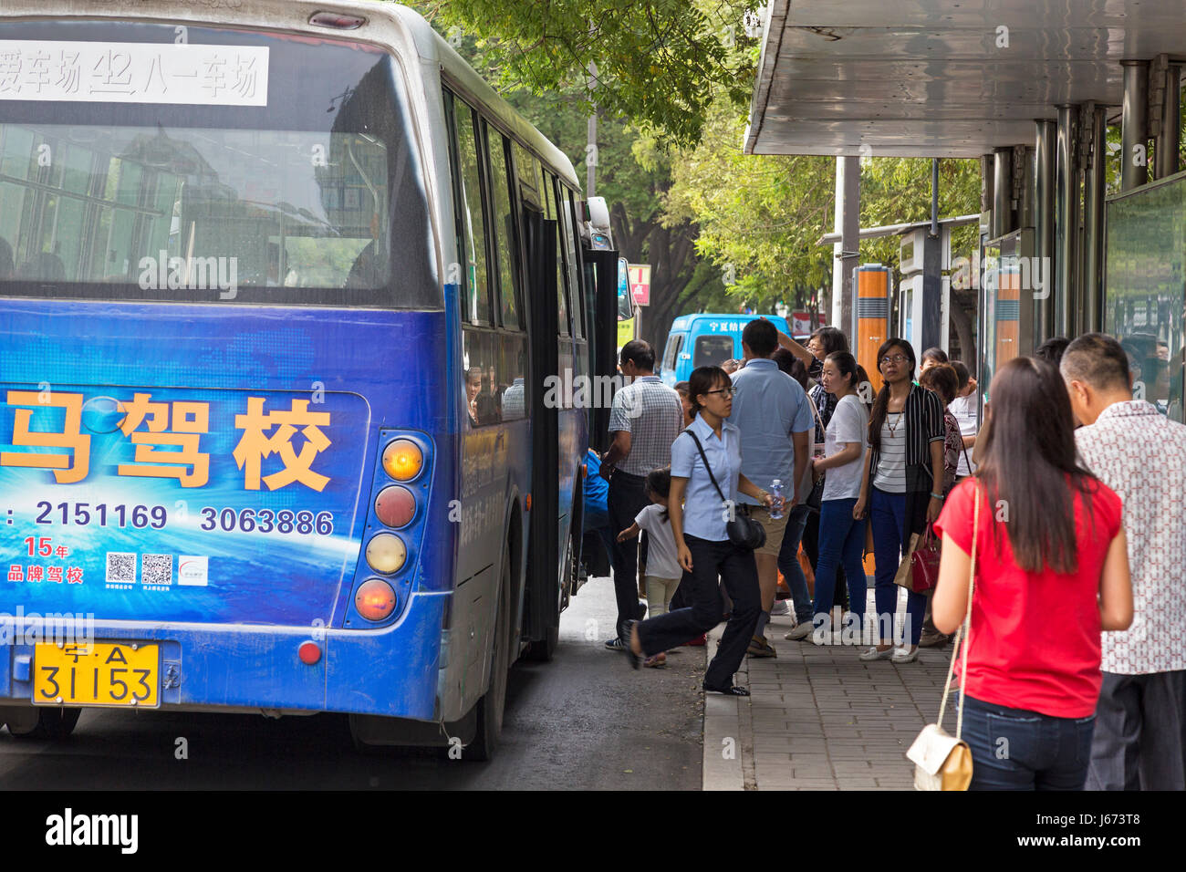 Les passagers chinois à l'arrêt de bus, Yinchuan, Ningxia, Chine Banque D'Images