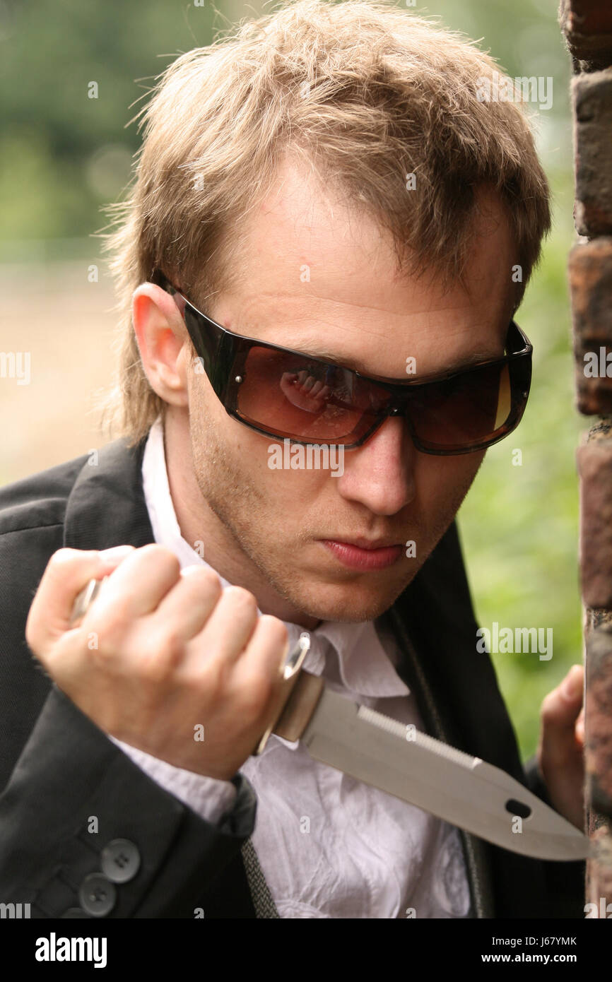 Mur de la mode lunettes de plein air couteau couteau arme le bras de sunglass man portrait Banque D'Images