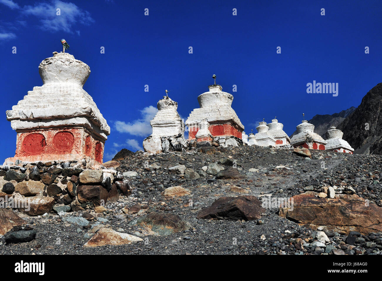De nombreuses anciennes sur stupa bouddhiste la pente raide de la montagne sous un ciel bleu : les stupas sont installés sur une colline pierreuse, ci-dessous sont des modèles rouge, th Banque D'Images