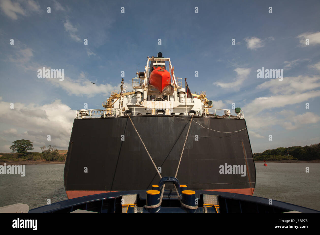 Tugboat retenant un grand navire dans le canal de Panama Banque D'Images