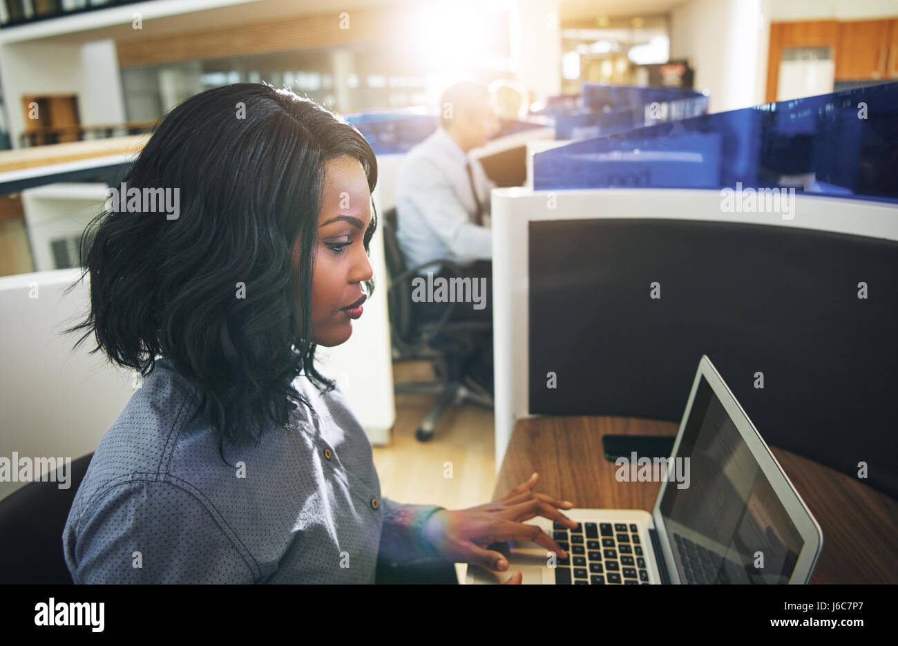Vue de côté de jolies jeunes femmes afro-américain employé travaillant à l'office. Banque D'Images