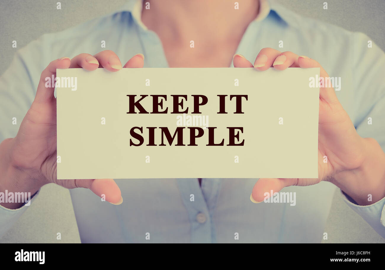 Image retro style instagram businesswoman hands holding white card signe avec rester simple texte de message isolé sur fond de bureau mur gris Banque D'Images