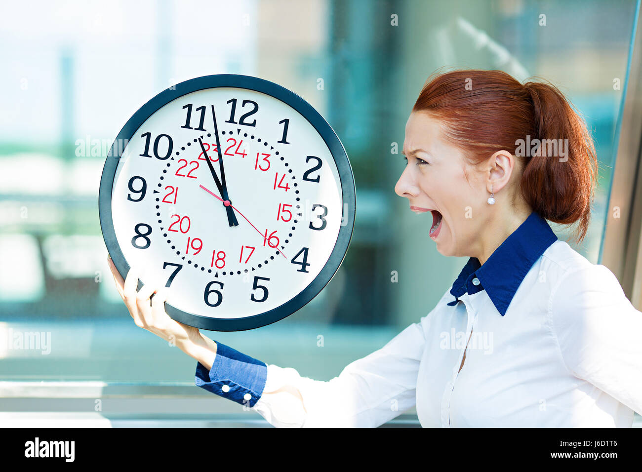 Closeup portrait femme d'affaires d'être en retard avec l'horloge dans les mains. Concept photo avec young businesswoman en hâte l'exécution contre le temps, isolé background Banque D'Images