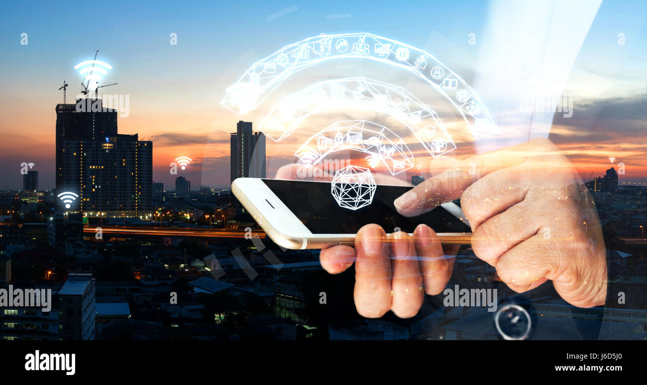 Internet des objets , Réseau , ito concept. Femme d'affaires à pointer du doigt l'écran noir téléphone mobile avec bâtiment Bâtiment de ville metropolis bac coucher du soleil Banque D'Images