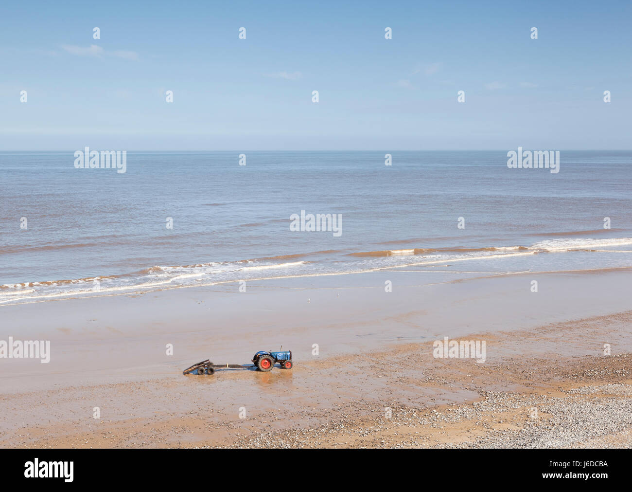 Un pêcheur le tracteur et remorque en attente sur plage de Cromer, Norfolk, UK Banque D'Images