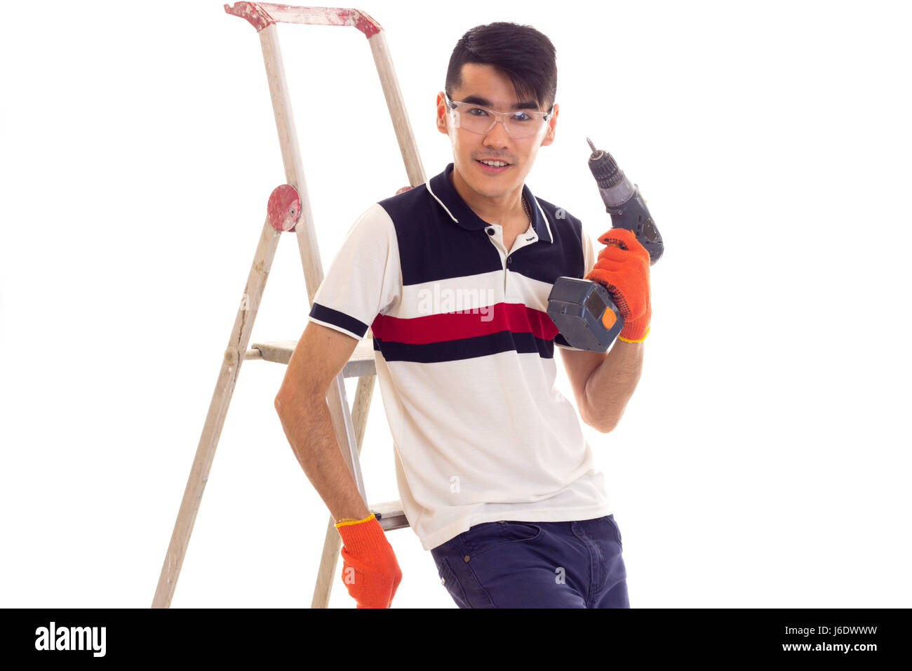 Young man holding tournevis électrique et assis sur ledder Banque D'Images