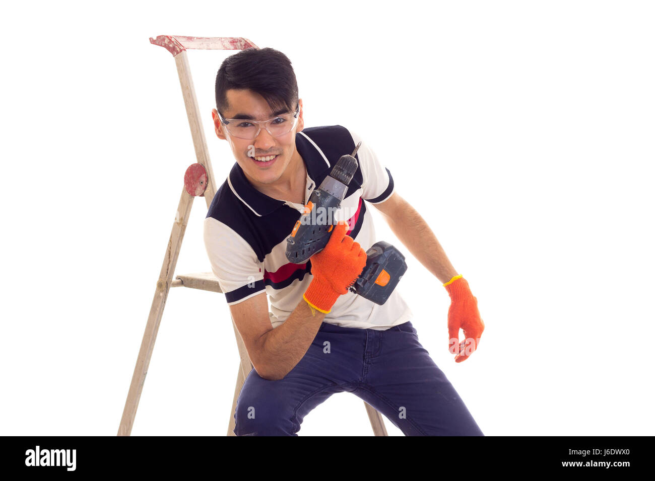 Young man holding tournevis électrique et assis sur ledder Banque D'Images