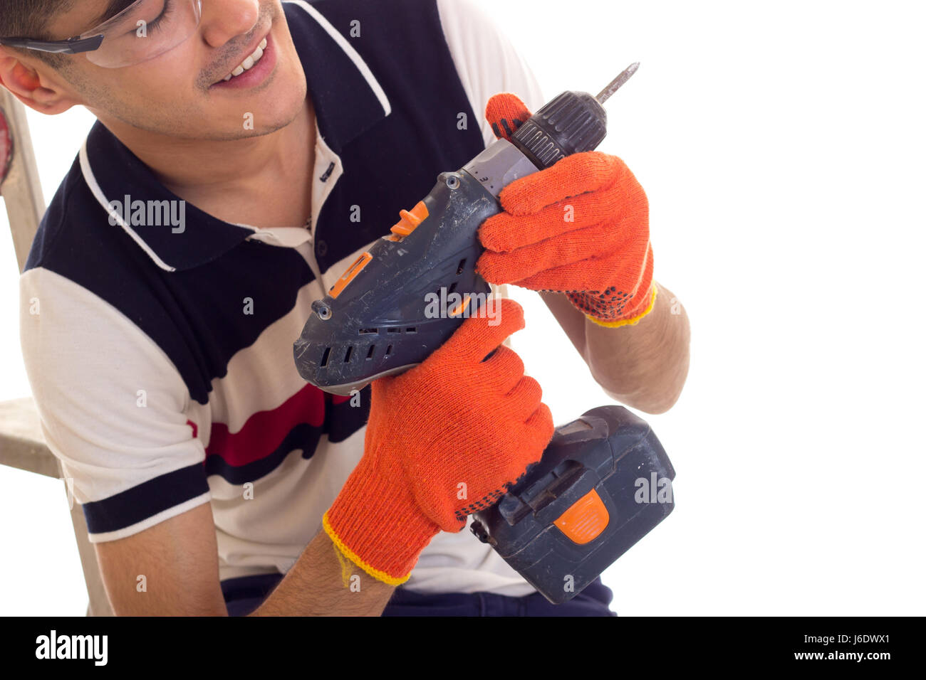 Young man holding tournevis électrique et assis sur ledder Banque D'Images
