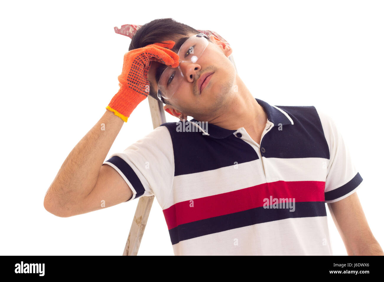 Young man holding tournevis électrique et assis sur ledder Banque D'Images