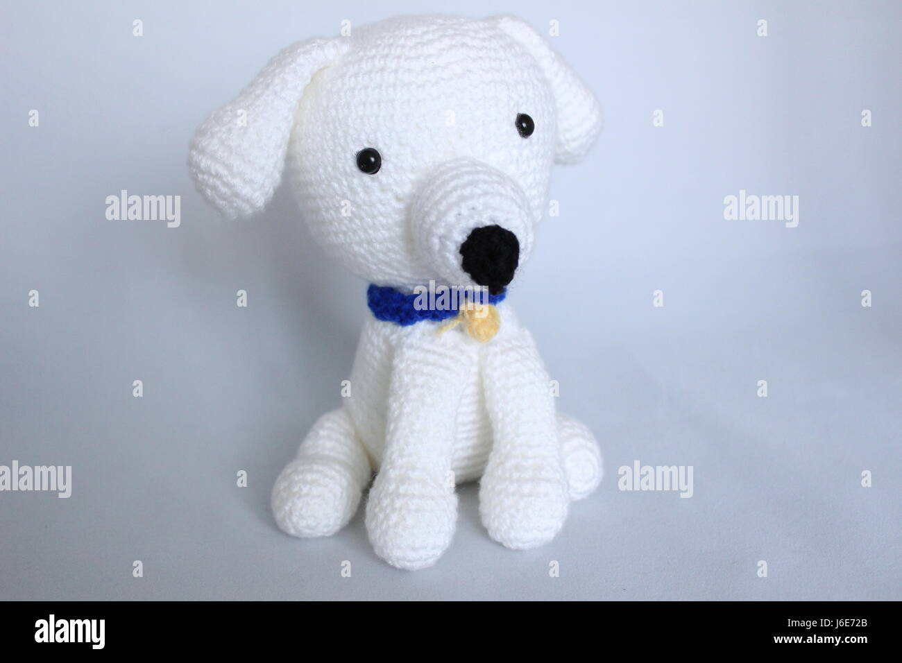 Chien blanc crochetés à la main des jouets posés sur fond blanc Banque D'Images