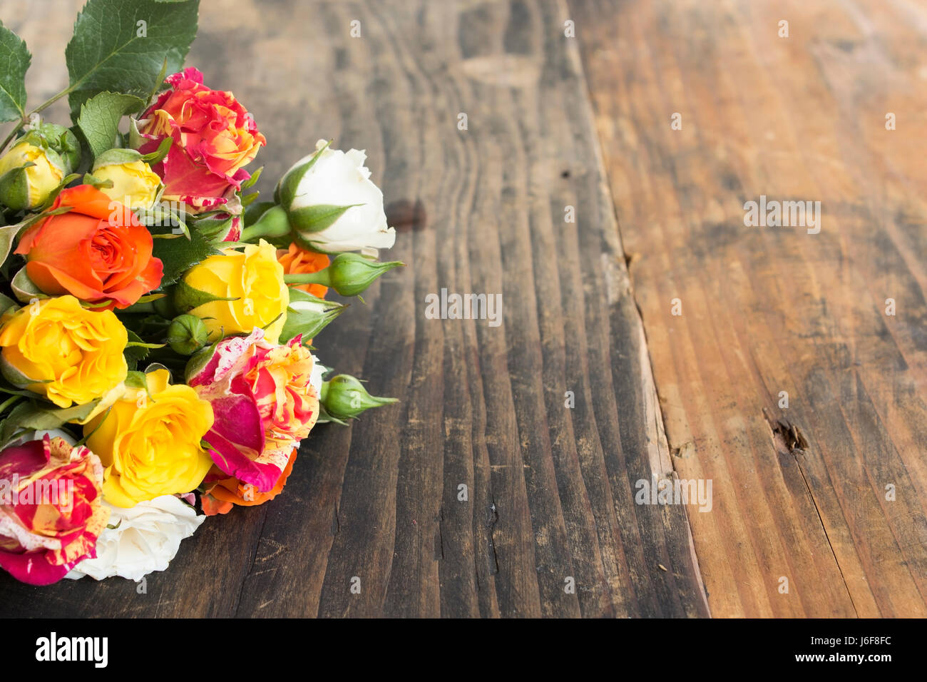L'espace de copie avec bouquet de roses multicolores sur un fond de bois rustique. Banque D'Images