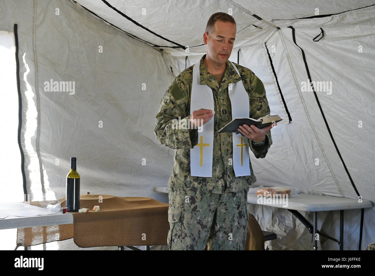 170514-N-DH124-038 FORT HUNTER LIGGETT, Californie (14 mai 2017) Le lieutenant Brady Rentz, un aumônier de la Marine affecté au bataillon de construction Mobile (NMCB), 4 lit un verset de la Bible pendant les services religieux à Fort Hunter Liggett, en Californie, au cours de l'exercice d'entraînement sur le terrain. NMCB-4 procède à leur classement final de l'exercice de formation sur le terrain, le test de l'élément de commandement, de contrôle et les fonctions de communication grâce à une variété de scénarios réels rencontrés pendant les déploiements. (U.S. Photo par marine Spécialiste de la communication de masse 1re classe Rosalie Chang/libérés) Banque D'Images