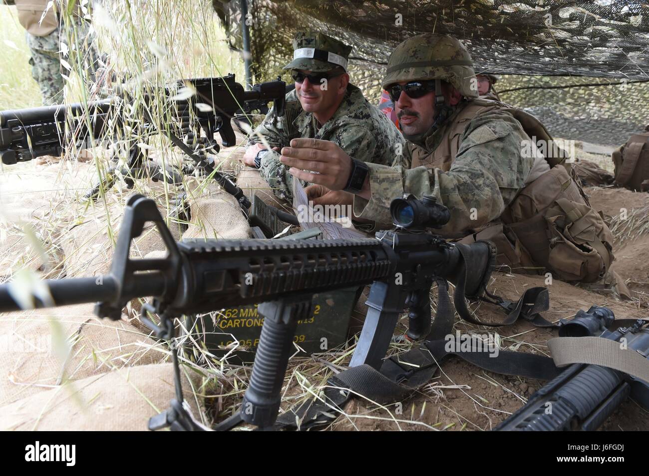 170515-N-DH124-157 FORT HUNTER LIGGETT, Californie (15 mai 2017) 3ème classe constructeur Robert Berry, affectés à la construction navale (bataillon Mobile NMCB) 4, explique ses secteurs défensifs d'un foyer d'incendie au Capitaine Mike Saum, commandant, Naval Construction Group (NCG) 1, au cours de l'exercice d'entraînement sur le terrain des bataillons (FTX). NMCB-4 procède à leur classement final FTX, test de l'élément de commandement, de contrôle et les fonctions de communication grâce à une variété de scénarios réels rencontrés pendant les déploiements. (U.S. Photo par marine Spécialiste de la communication de masse 1re classe Rosalie Chang/libérés) Banque D'Images