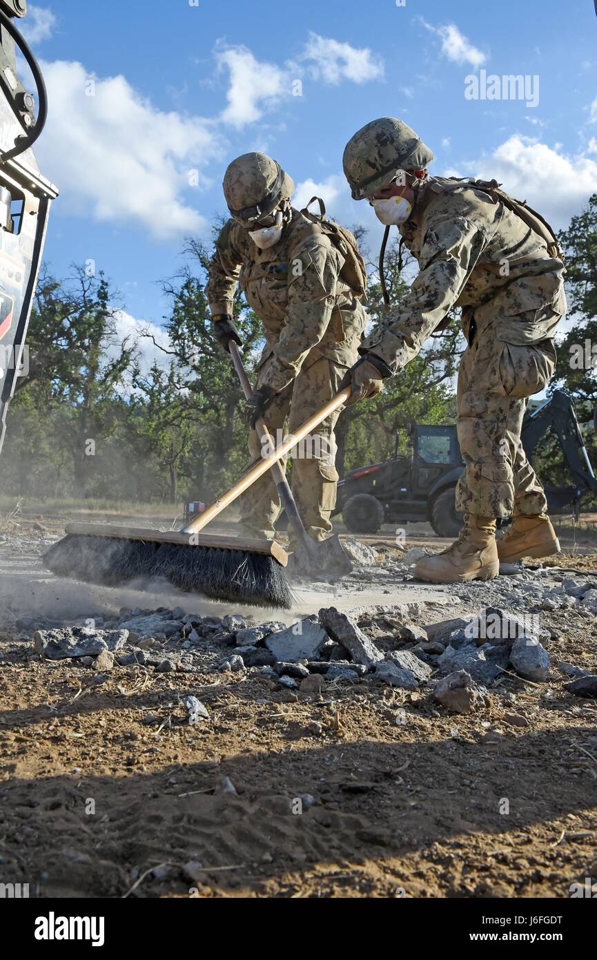 170515-N-DH124-527 FORT HUNTER LIGGETT, Californie (15 mai 2017) attribué à Seabees Mobile Naval Construction Battalion (NMCB) 4 Retirez les débris d'une exfoliation afin de réparer les dégâts de la simulation d'un airstrikeat Fort Hunter Liggett, en Californie, au cours de l'exercice d'entraînement sur le terrain des bataillons. L'exercice donne l'occasion de pratiquer Seabees et appliquer des compétences de guerre combat seabee, fournir l'appui de la sécurité de la nation hôte et rester prêt de la mission dans un environnement simulé destiné à reproduire dans le pays de la paix. (U.S. Photo par marine Spécialiste de la communication de masse 1re classe Rosalie Chang/relâché Banque D'Images
