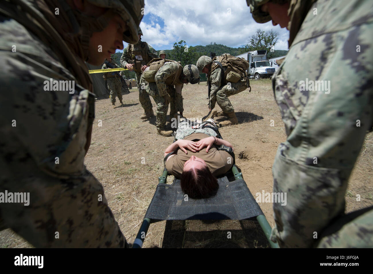 170515-N-XJ502-103 FORT HUNTER LIGGETT, Californie (15 mai 2017) - Seabees, affectés à la construction navale (bataillon Mobile NMCB) 4, se préparer à faire litière une victime simulée pendant un grand nombre de blessés pour forage NMCB 4 Exercice de formation sur le terrain (FTX). Le FTX prépare et teste la capacité du bataillon d'entrer dans des endroits hostiles, construire des projets de construction attribué et se défendre contre les attaques ennemies à l'aide de scénarios réalistes tout en étant évalué par la construction navale Groupe 1. (U.S. Photo de la marine par Utilitiesman 2e classe Jasmine Flores/libérés) Banque D'Images