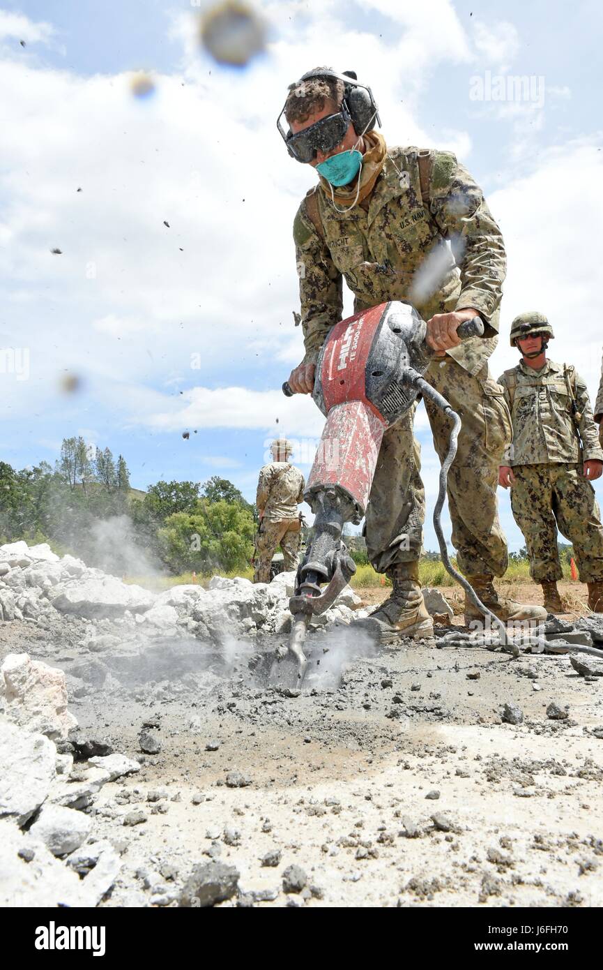 170516-N-DH124-623 FORT HUNTER LIGGETT, Californie (16 mai 2017) Builder Constructionman Heith Wright, affectés à la construction navale (bataillon Mobile NMCB) 4, utilise un marteau-piqueur pour briser le ciment autour d'un cratère pour réparer les dégâts d'une attaque aérienne simulée au cours de l'exercice d'entraînement sur le terrain des bataillons (FTX). NMCB-4 procède à leur classement final FTX, test de l'élément de commandement, de contrôle et les fonctions de communication grâce à une variété de scénarios réels rencontrés pendant les déploiements. (U.S. Photo par marine Spécialiste de la communication de masse 1re classe Rosalie Chang/libérés) Banque D'Images
