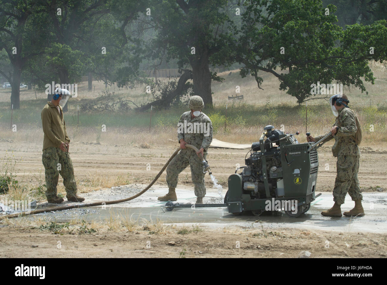 170516-N-XJ502-180 FORT HUNTER LIGGETT, Californie (16 mai 2017) - Seabees, affectés à la construction navale (bataillon Mobile NMCB) 4, verser d'eau sur un cratère rempli de liquide de remplissage, un séchage rapide tout en menant de béton réparation de dommages pendant l'aérodrome NMCB 4 Exercice de formation sur le terrain (FTX). Le FTX prépare et teste la capacité du bataillon d'entrer dans des endroits hostiles, construire des projets de construction attribué et se défendre contre les attaques ennemies à l'aide de scénarios réalistes tout en étant évalué par la construction navale Groupe 1. (U.S. Photo de la marine par Utilitiesman 2e classe Jasmine Flores/libérés) Banque D'Images