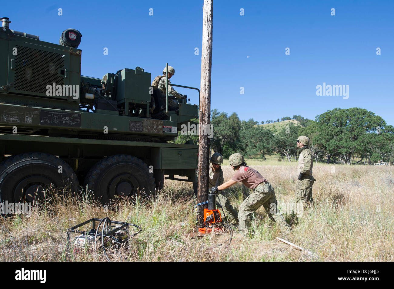 170517-N-XJ502-002 FORT HUNTER LIGGETT, Californie (17 mai 2017) - Seabees, affectés à la construction navale (bataillon Mobile NMCB) 4, retirer la communication endommagés au cours de polonais NMCB 4 Exercice de formation sur le terrain (FTX). Le FTX prépare et teste la capacité du bataillon d'entrer dans des endroits hostiles, construire des projets de construction attribué et se défendre contre les attaques ennemies à l'aide de scénarios réalistes tout en étant évalué par la construction navale Groupe 1. (U.S. Photo de la marine par Utilitiesman 2e classe Jasmine Flores/libérés) Banque D'Images