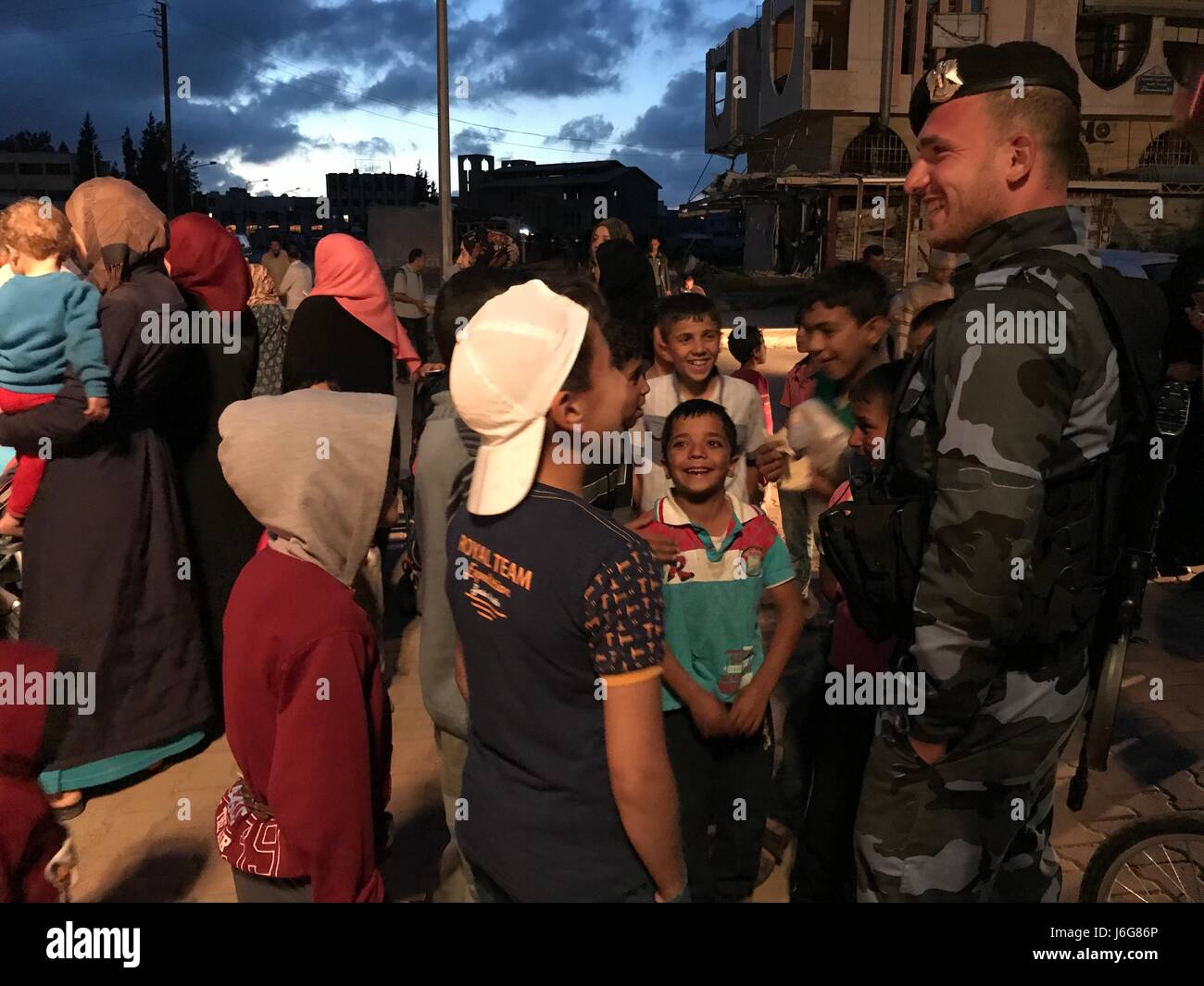 Homs, en Syrie. 21ème mai 2017. Les enfants syriens rire avec un soldat syrien dans le quartier al-Waer dans la ville de Homs, en Syrie, le 21 mai 2017. Le dernier lot de rebelles évacué leur dernier bastion dans le quartier al-Waer, faisant de l'ensemble de la ville sous le contrôle du gouvernement. Le dernier autobus transportant des rebelles et leurs familles évacuées al-Waer quartier, leur dernier bastion dans la ville de Homs. Source : Xinhua/Alamy Live News Banque D'Images