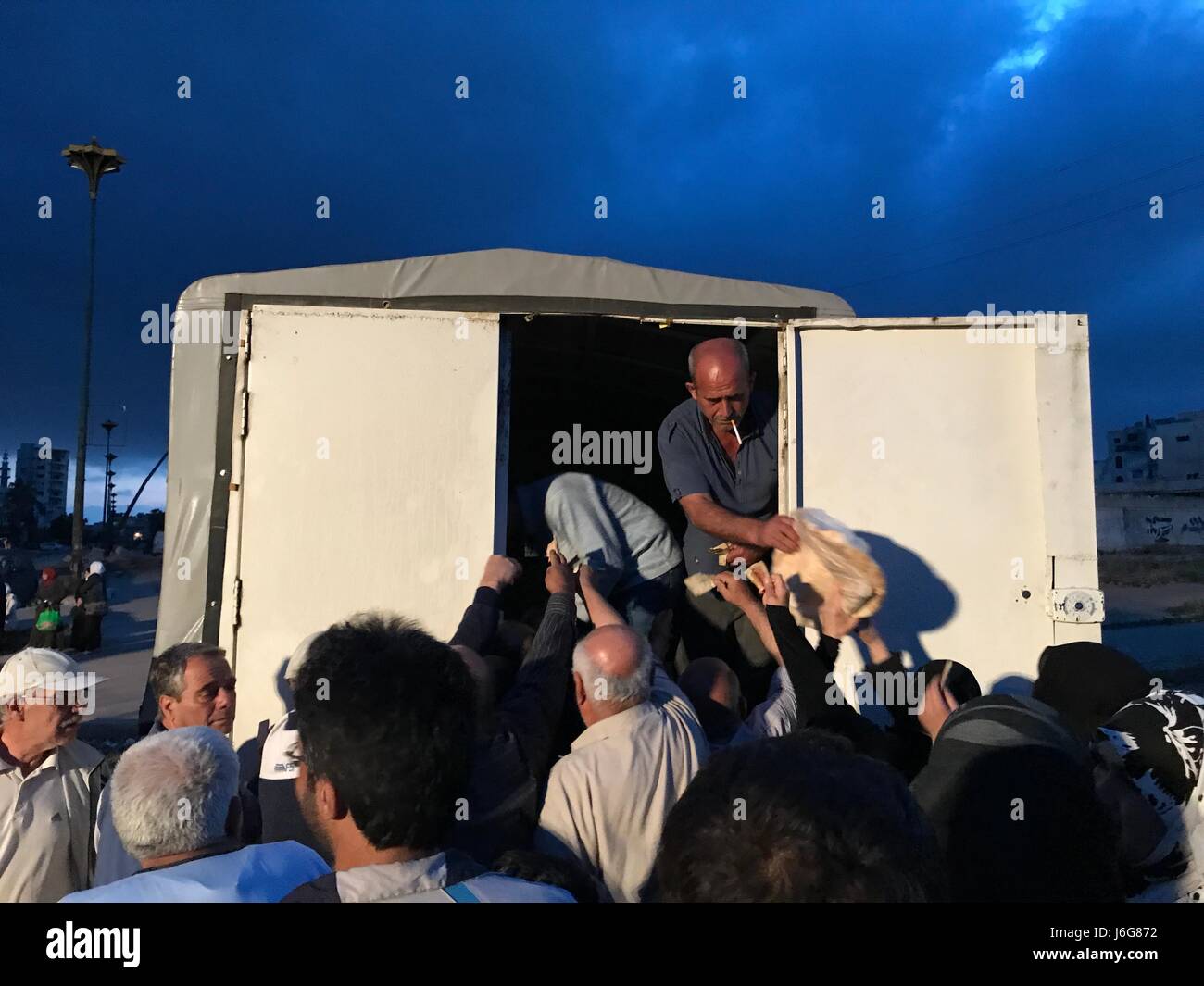 Homs, en Syrie. 21ème mai 2017. Les gens achètent du pain dans le quartier al-Waer dans la ville de Homs, en Syrie, le 21 mai 2017. Le dernier lot de rebelles évacué leur dernier bastion dans le quartier al-Waer, faisant de l'ensemble de la ville sous le contrôle du gouvernement. Le dernier autobus transportant des rebelles et leurs familles évacuées al-Waer quartier, leur dernier bastion dans la ville de Homs. Source : Xinhua/Alamy Live News Banque D'Images