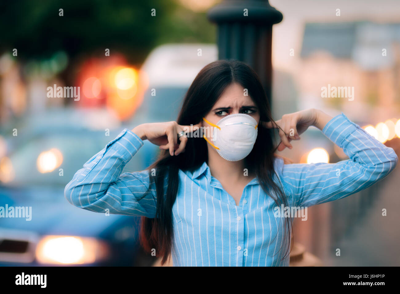 Girl avec masque couvrant ses oreilles à cause de la pollution par le bruit Banque D'Images