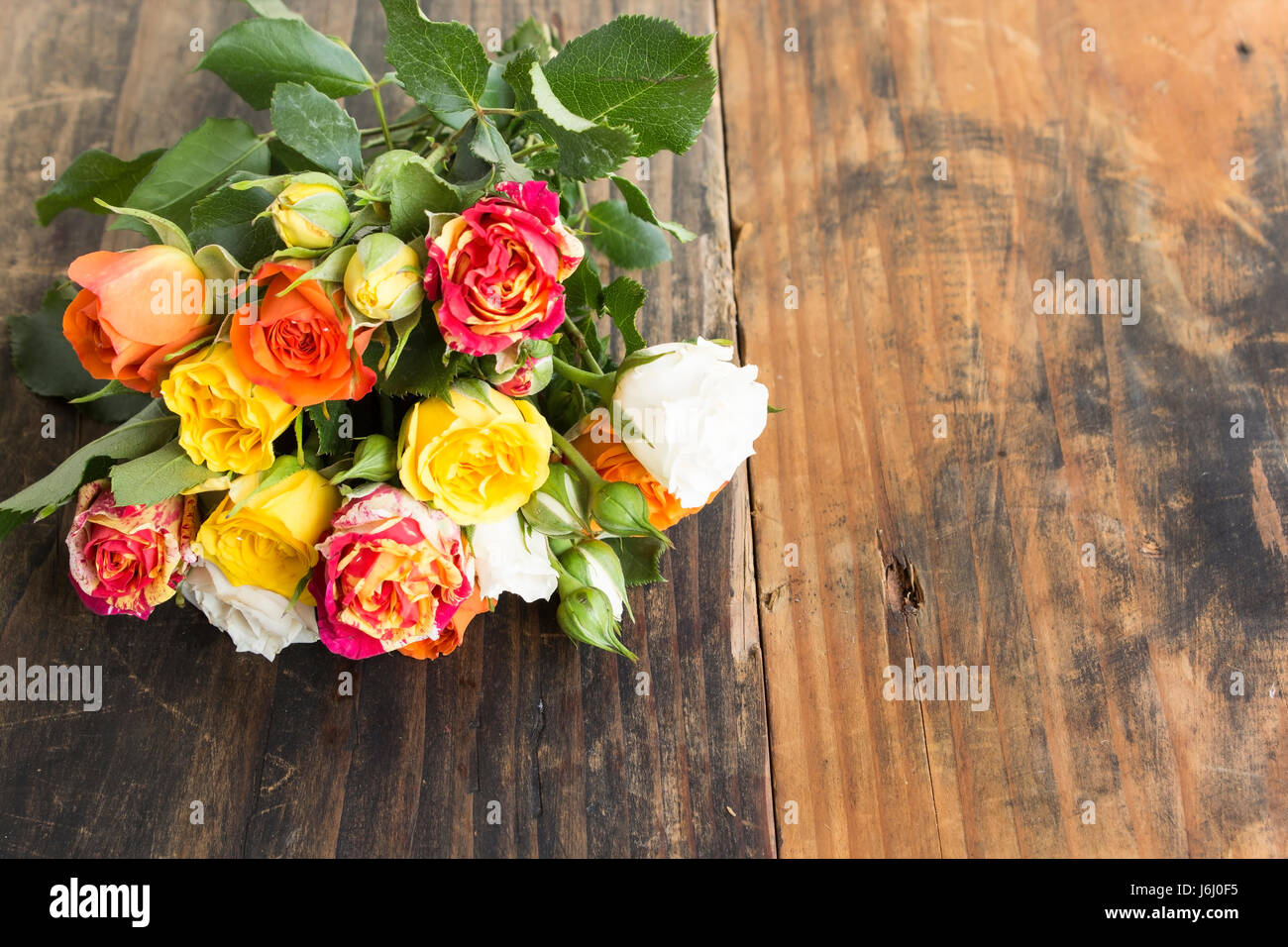 Bouquet de roses multicolores avec l'exemplaire de l'espace sur un fond de bois rustique. Banque D'Images