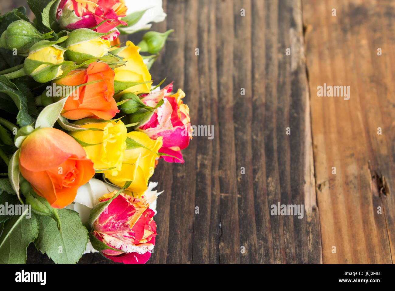 Bouquet de roses multicolores avec l'exemplaire de l'espace sur un fond de bois rustique. Banque D'Images